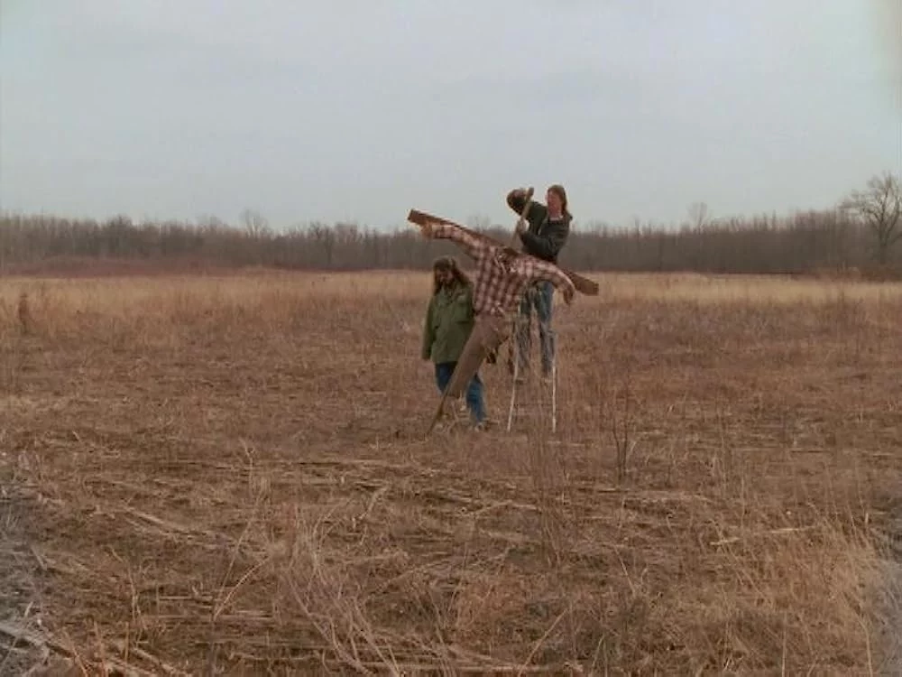 Mark Borchardt and Mike Schank in a bleak wintery field setting up a scarecrow for use in their film Coven.